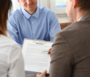 GettyImages-1423023466 People reviewing a contract at a meeting.